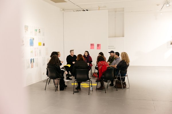 A group of people sitting in a circle on chairs in a gallery space at Adelaide Contemporary Experimental.