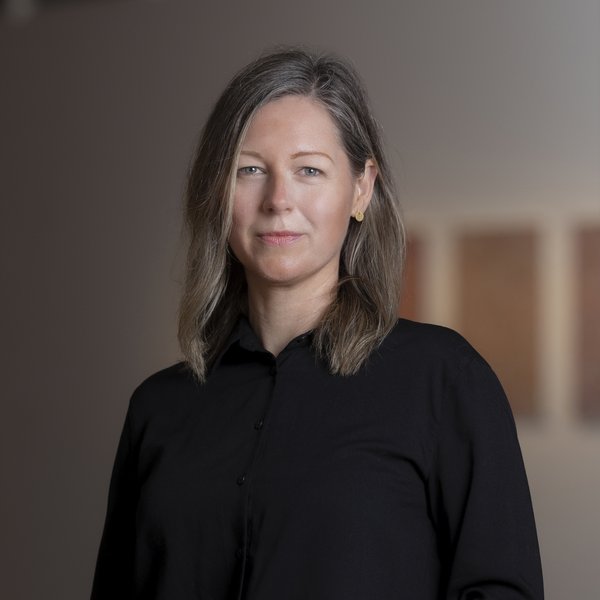 Photo of Janice Falsone. She has light shoulder length hair and is wearing a black shirt.