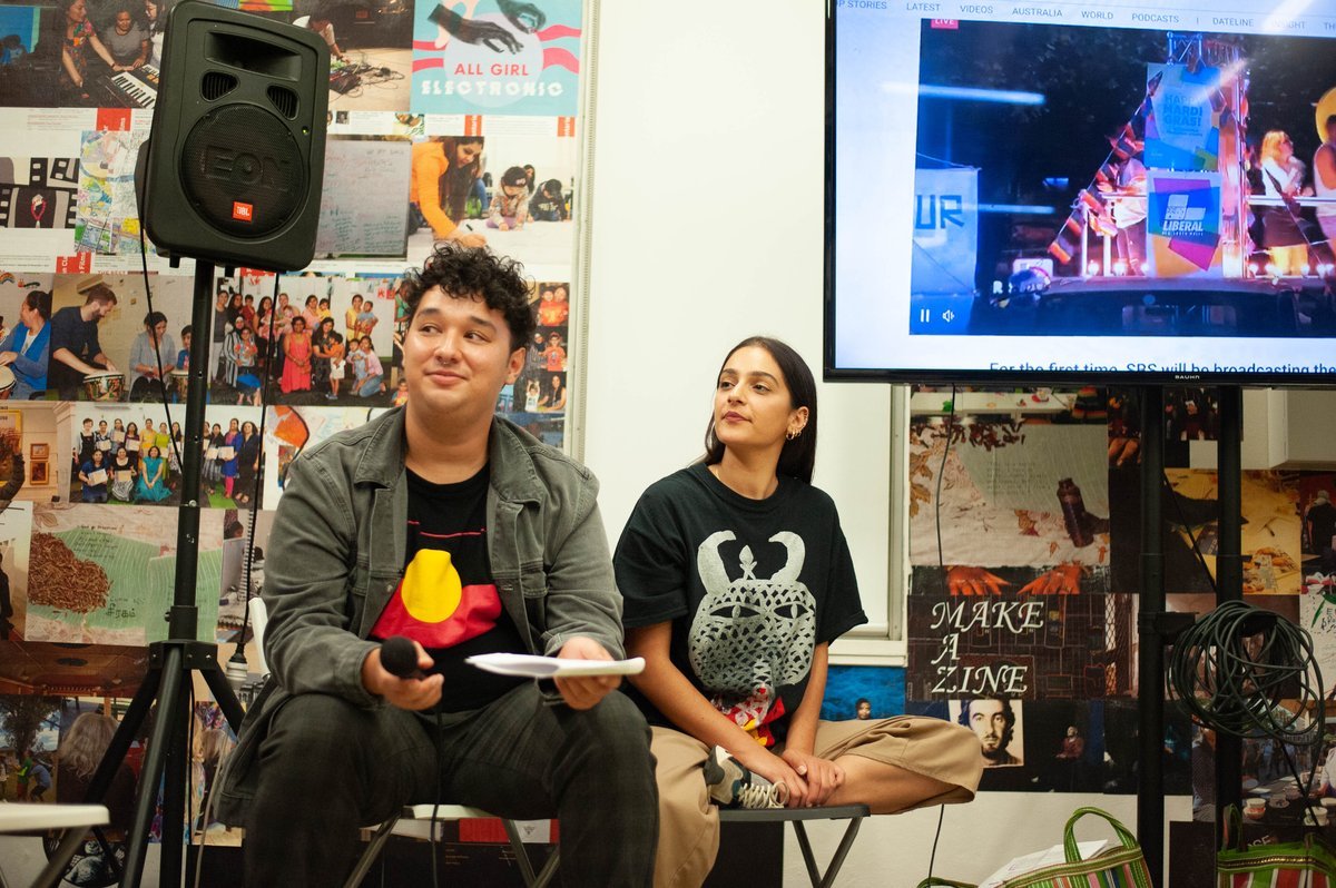 facilitators Enoch Mailangi and Justine Youssef next to a screen depicting the Department of Homo Affairs' 2020 Sydney Mardi Gras action. 