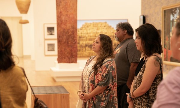 Three adults standing in a gallery at QAGOMA.