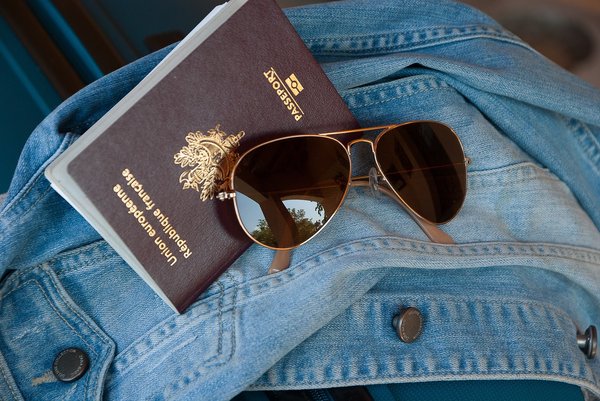 Sunglasses, passport on denim jacket